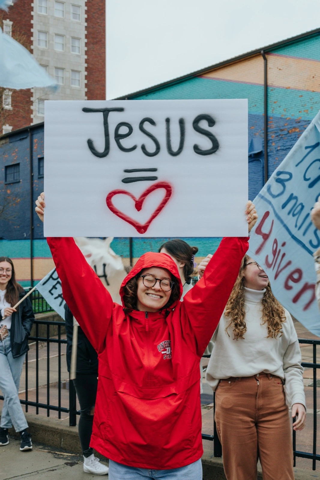 Student holding a Jesus sign outside